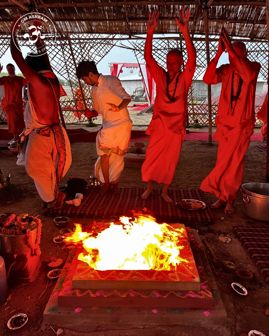Devotees celebrating with raised hands at OM Ashram.